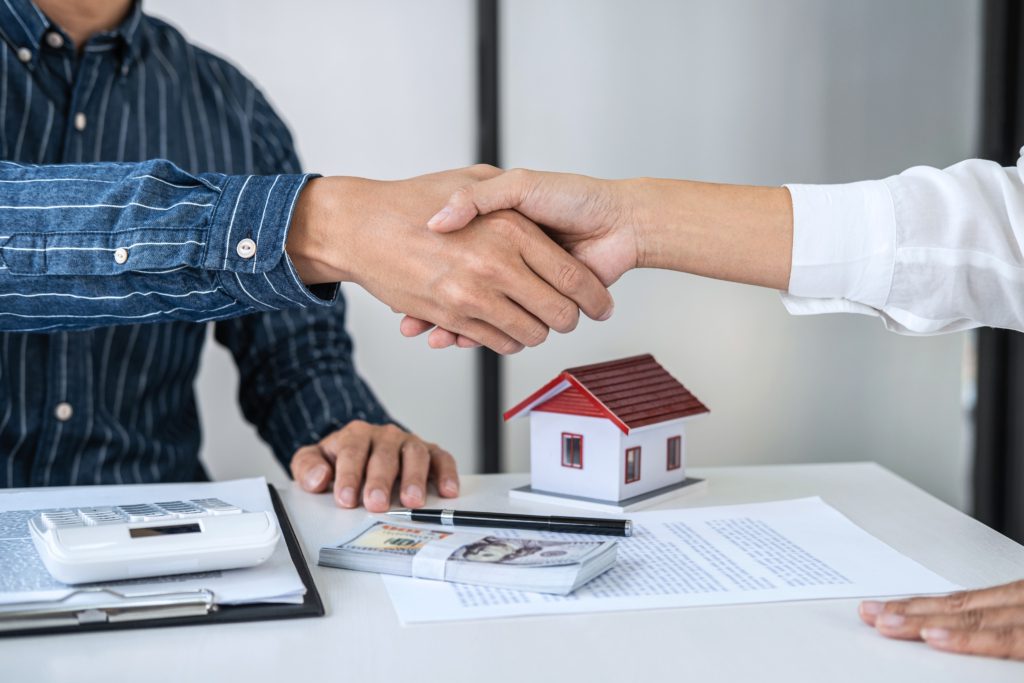 Real estate agent and customers shaking hands together celebrati