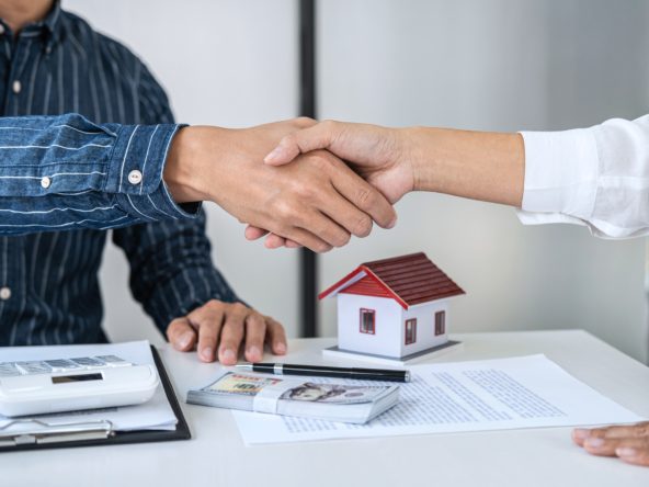 Real estate agent and customers shaking hands together celebrati