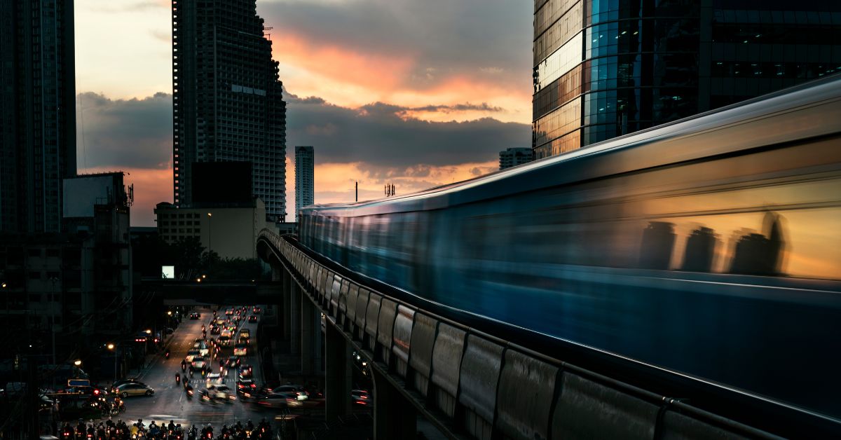 An evening view of moving BTS on its rail with the nice city scape fill with orange sunset sky